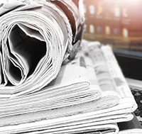 A laptop and newspapers